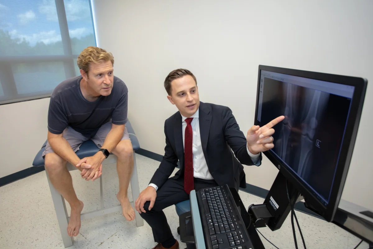 Dr. Grosso reviewing an X-ray on a monitor with a patient.